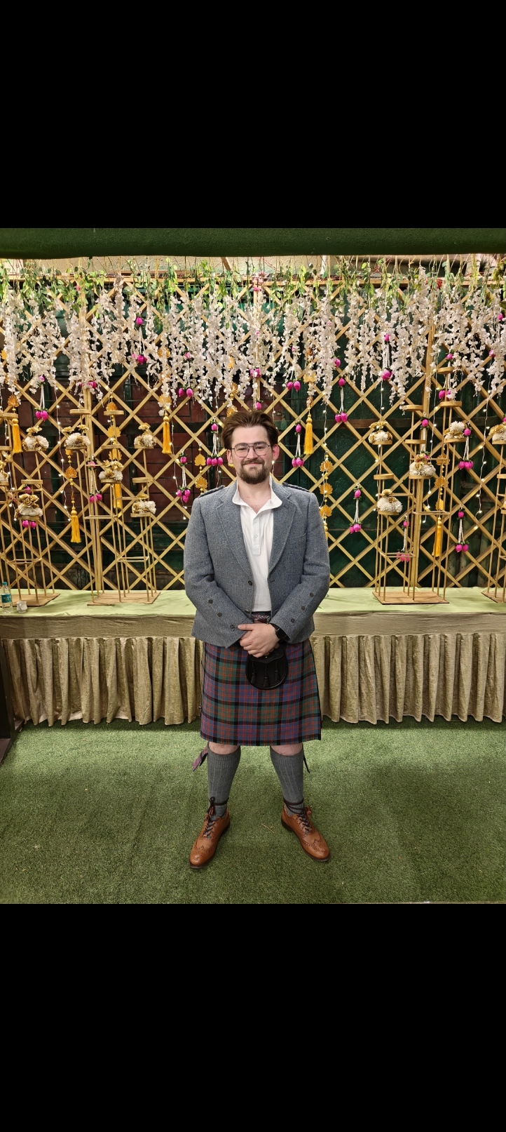 Alex Binyon standing in front of a handcrafted floral installation